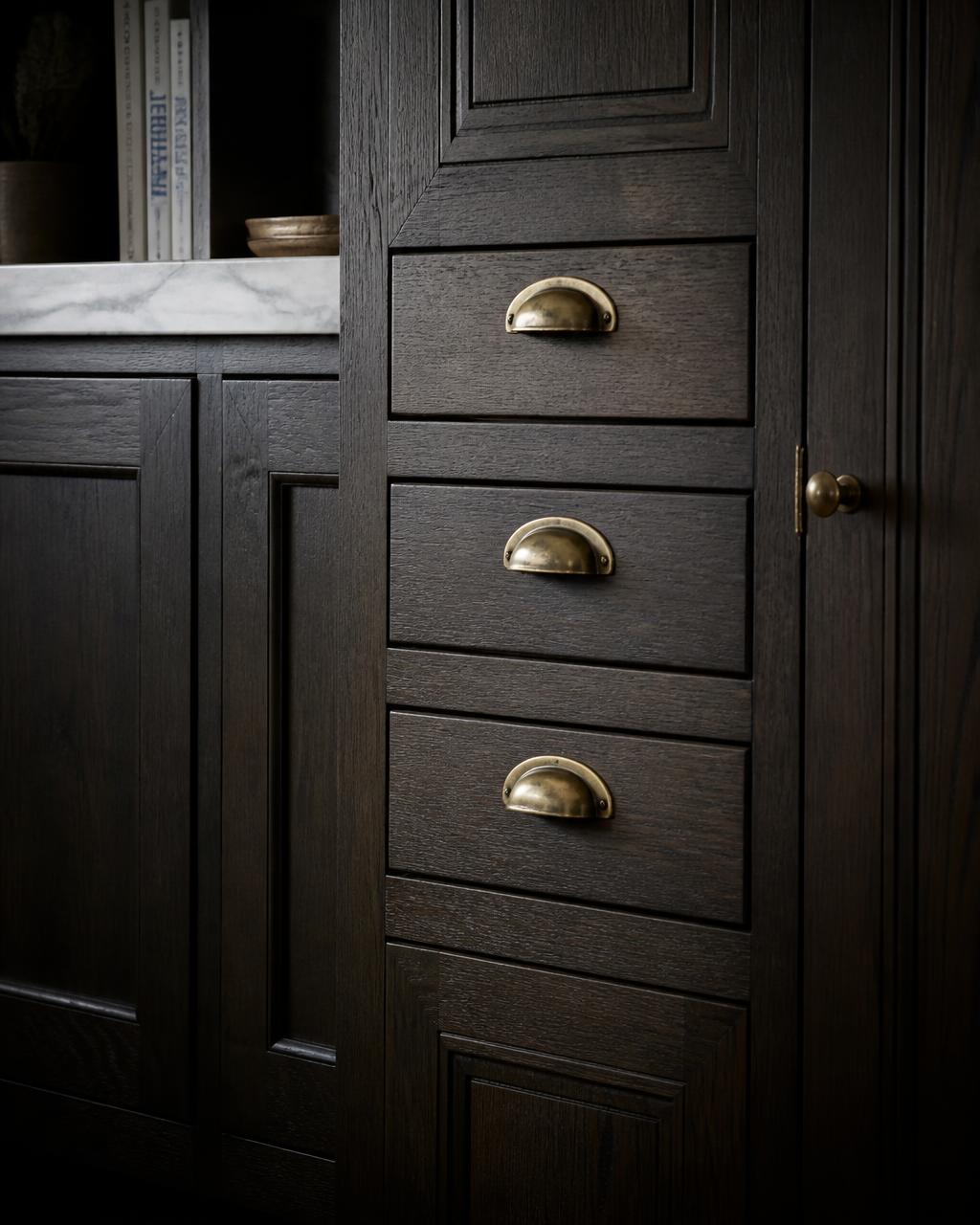 Luxury inset kitchen cabinets in dark stained oak with aged brass pulls